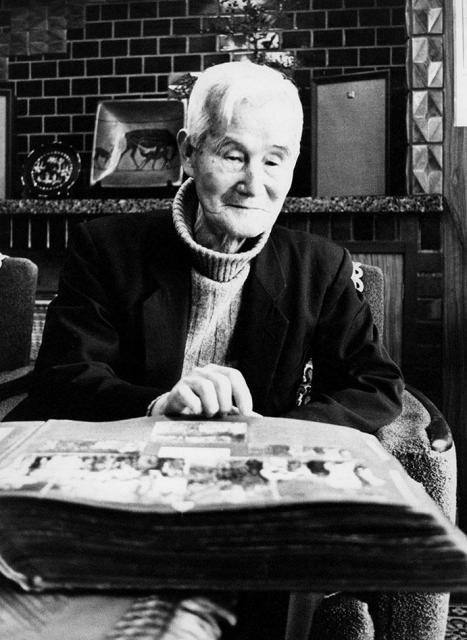 『大谷探検隊写真帖』を見る吉川小一郎　昭和52年（1977）　吉川家（無断掲載不可）